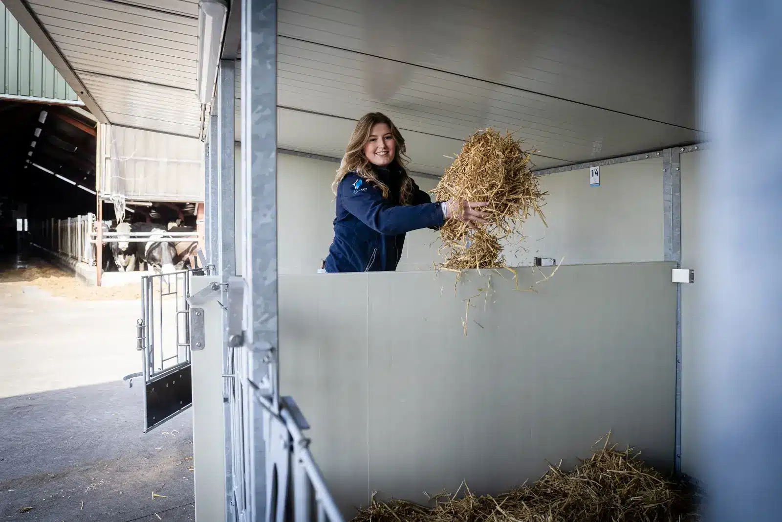 Een medewerker legt vers stro in een lege ligplaats