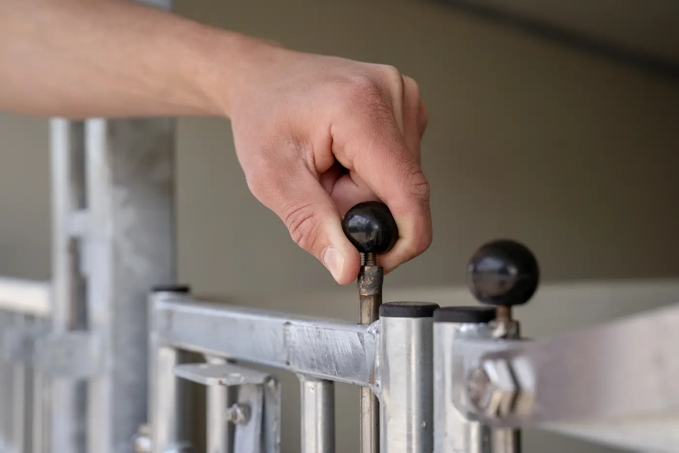 Hand opent de vergrendeling van het fronthek met een zwarte knop